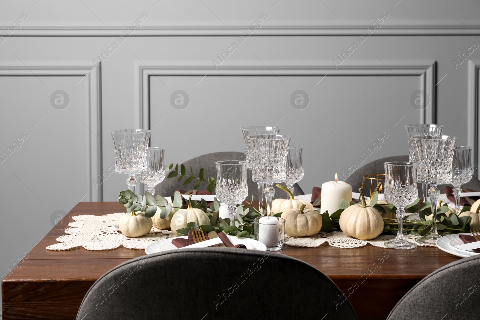 Photo of Beautiful autumn table setting. Plates, cutlery, glasses, pumpkins and floral decor