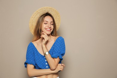 Photo of Beautiful young woman wearing straw hat on beige background, space for text. Stylish headdress