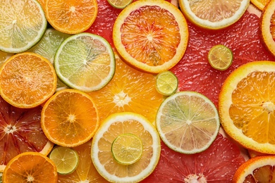 Slices of fresh citrus fruits as background, top view