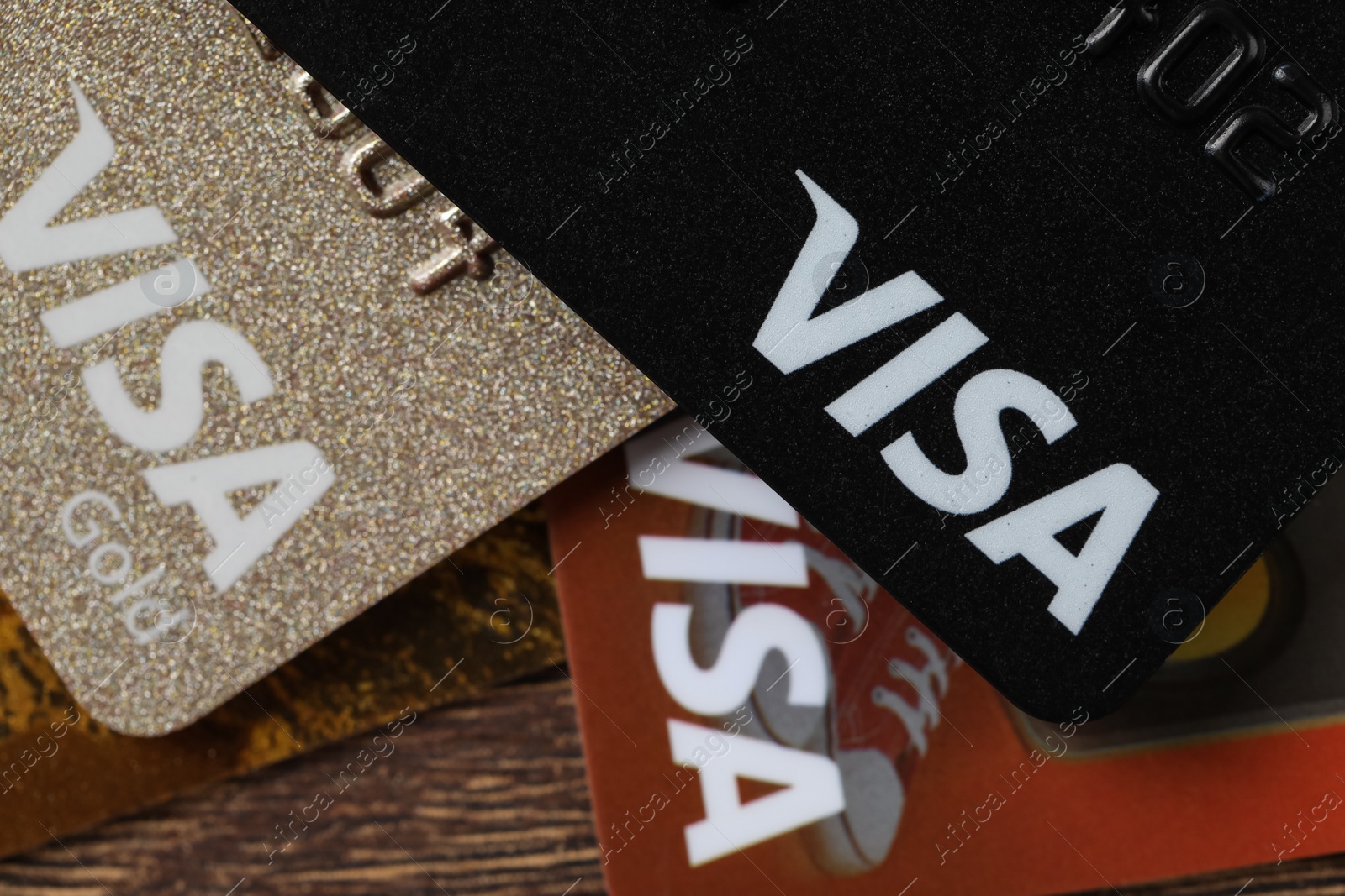 Photo of MYKOLAIV, UKRAINE - FEBRUARY 22, 2022: Visa credit cards on wooden table, closeup