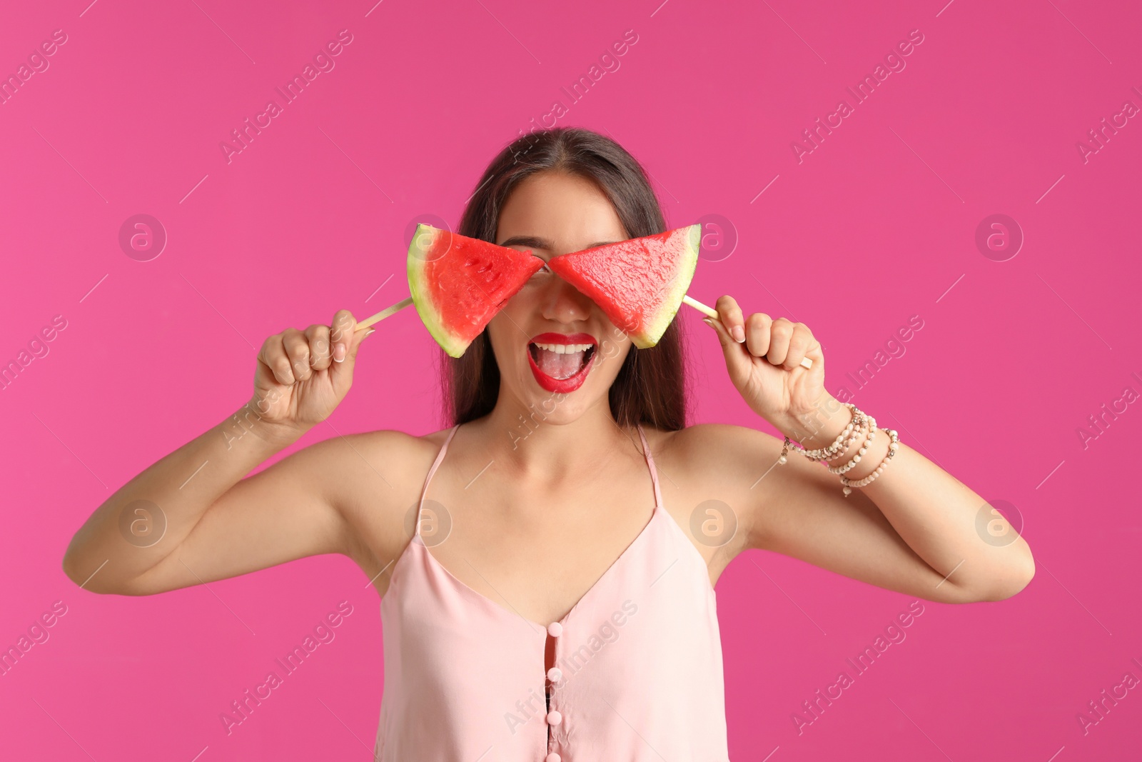 Photo of Beautiful young woman posing with watermelon on color background