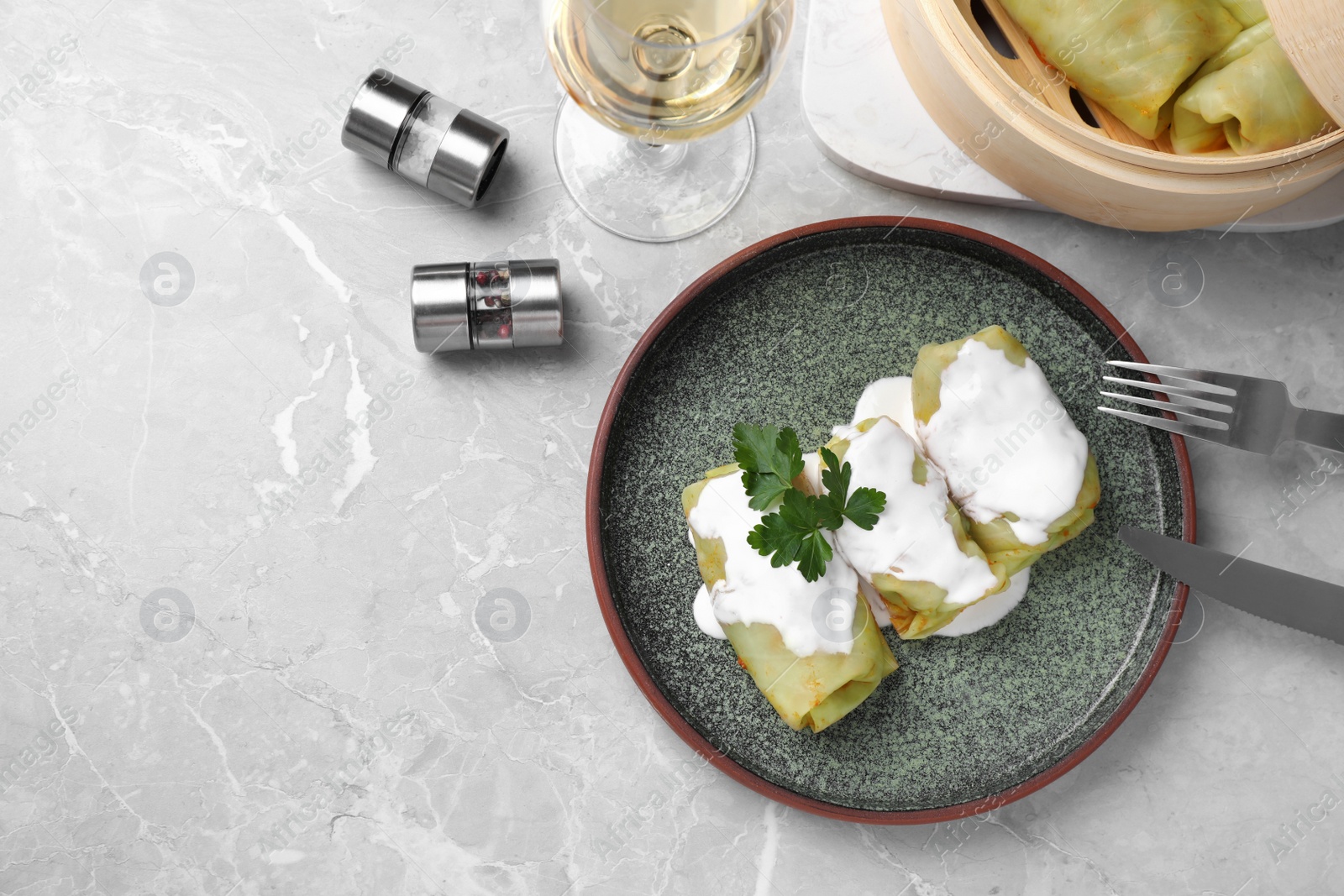 Photo of Delicious cabbage rolls served on grey marble table, flat lay. Space for text