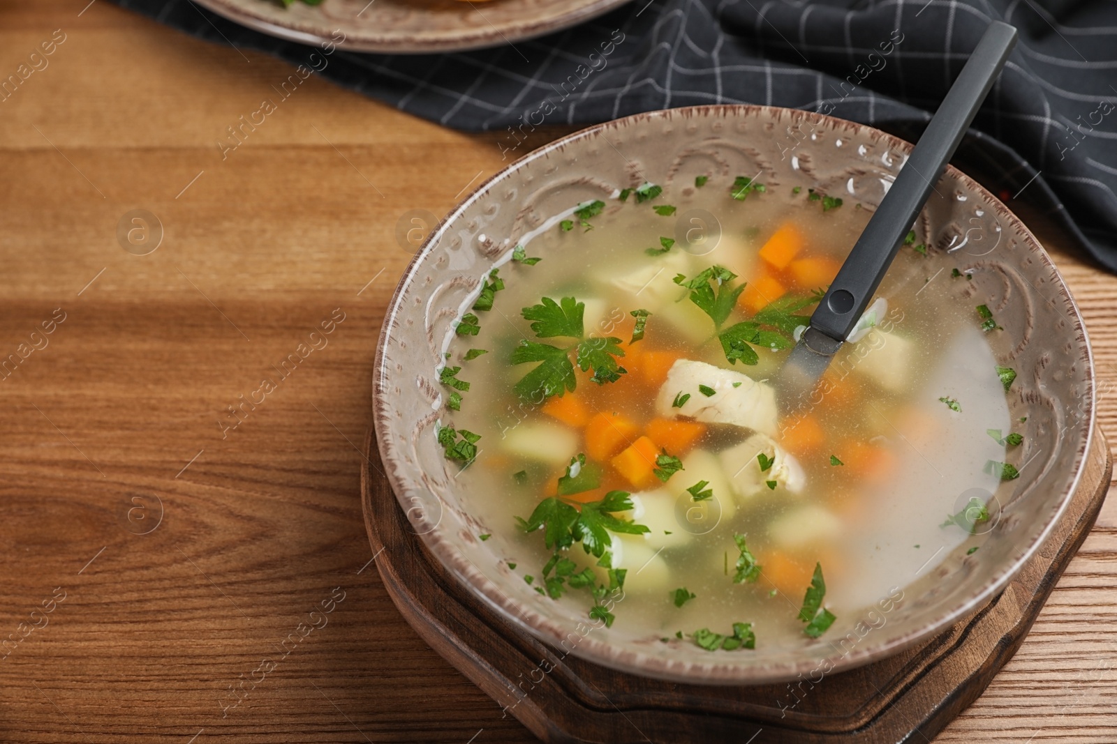 Photo of Bowl of fresh homemade soup to cure flu on wooden table