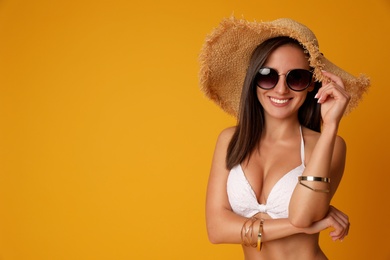 Photo of Pretty sexy woman with slim body in stylish  white bikini on orange background, space for text