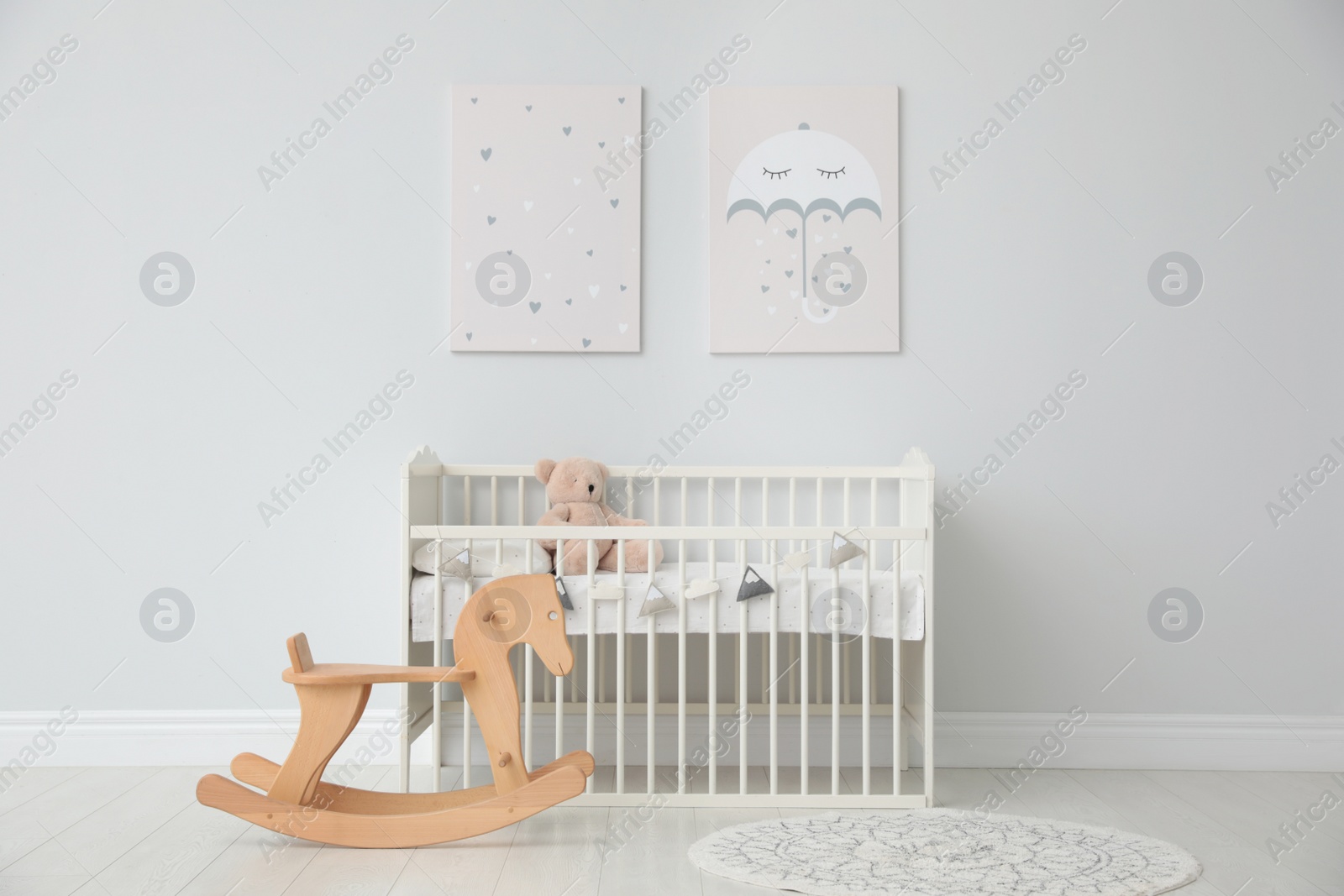 Photo of Minimalist room interior with baby crib, decor elements and toys