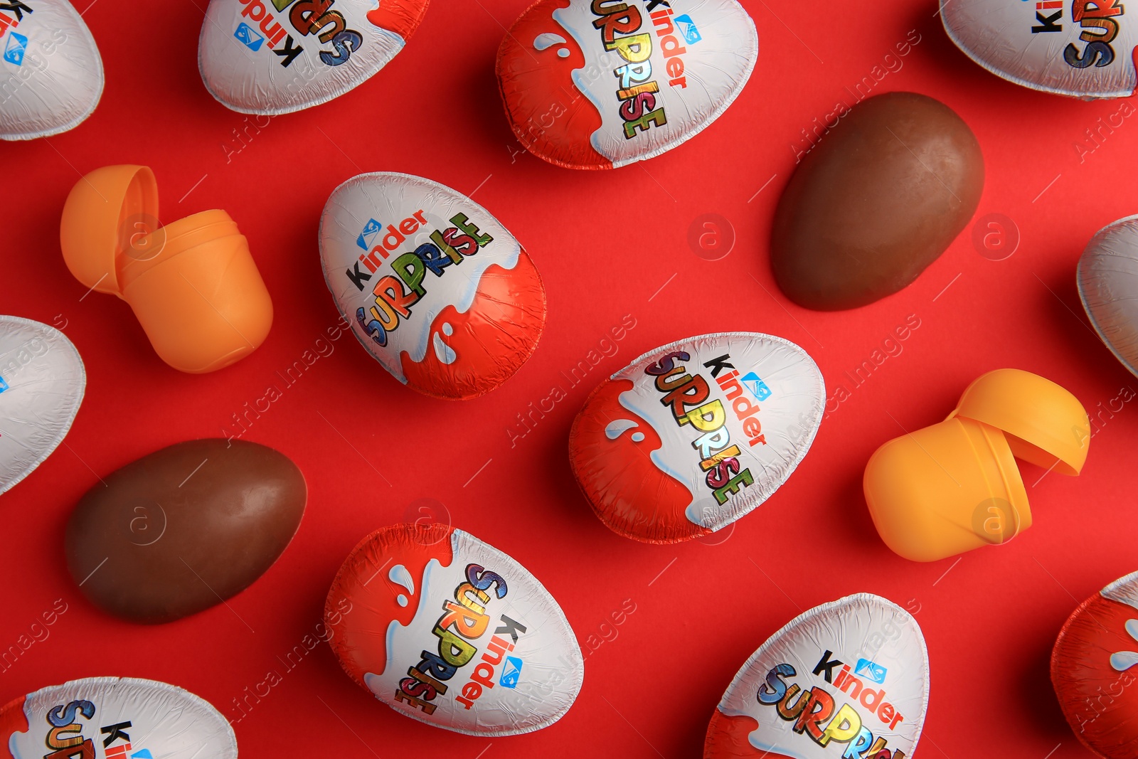 Photo of Sveti Vlas, Bulgaria - June 27, 2023: Kinder Surprise Eggs and plastic containers on red background, flat lay