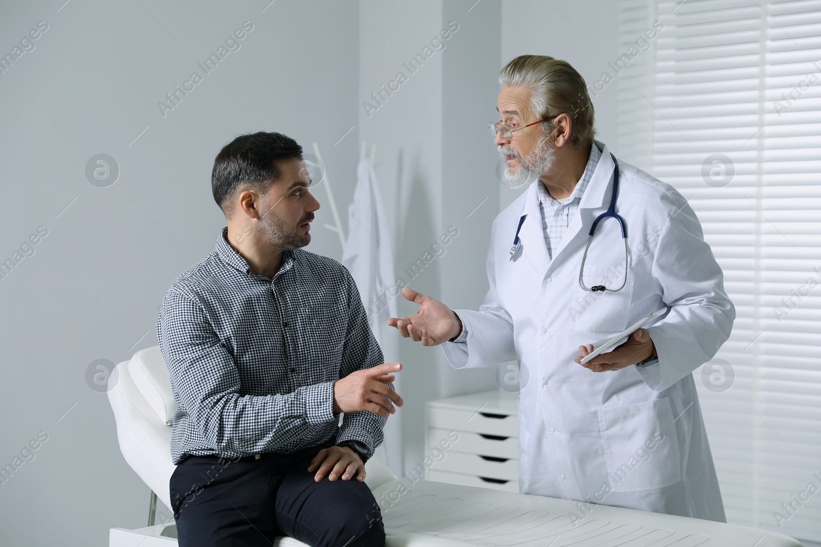 Photo of Patient having appointment with senior doctor in clinic