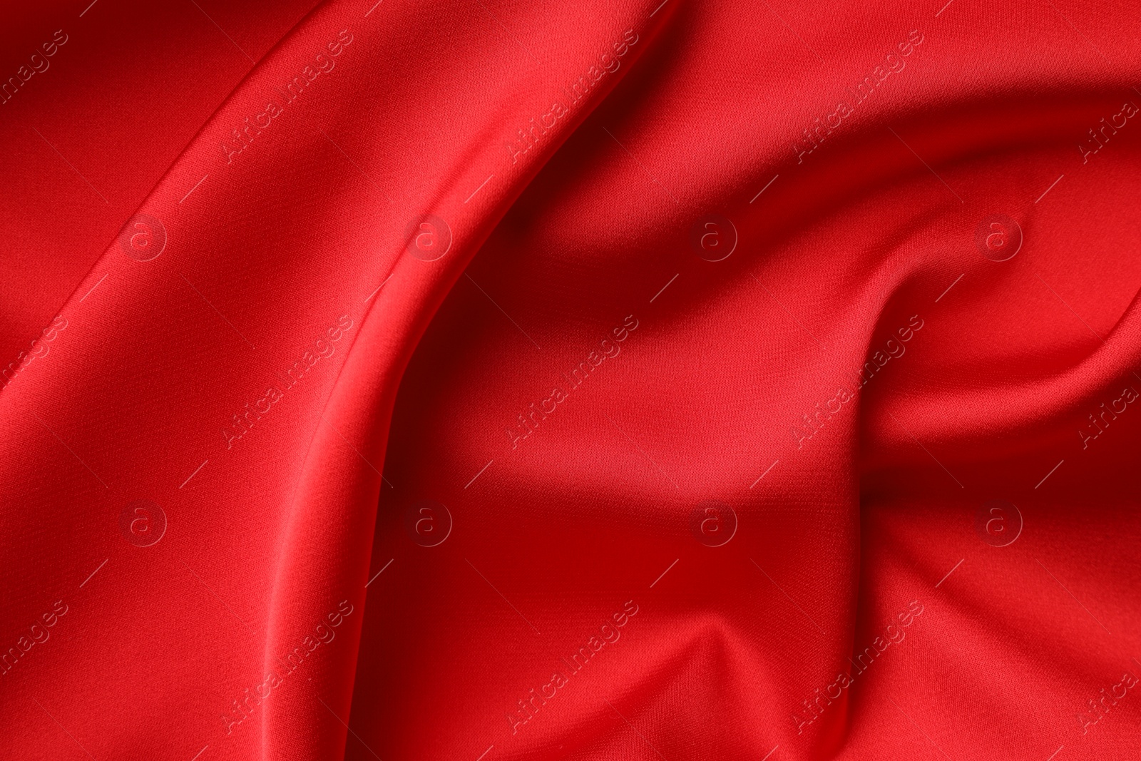 Photo of Crumpled red silk fabric as background, top view