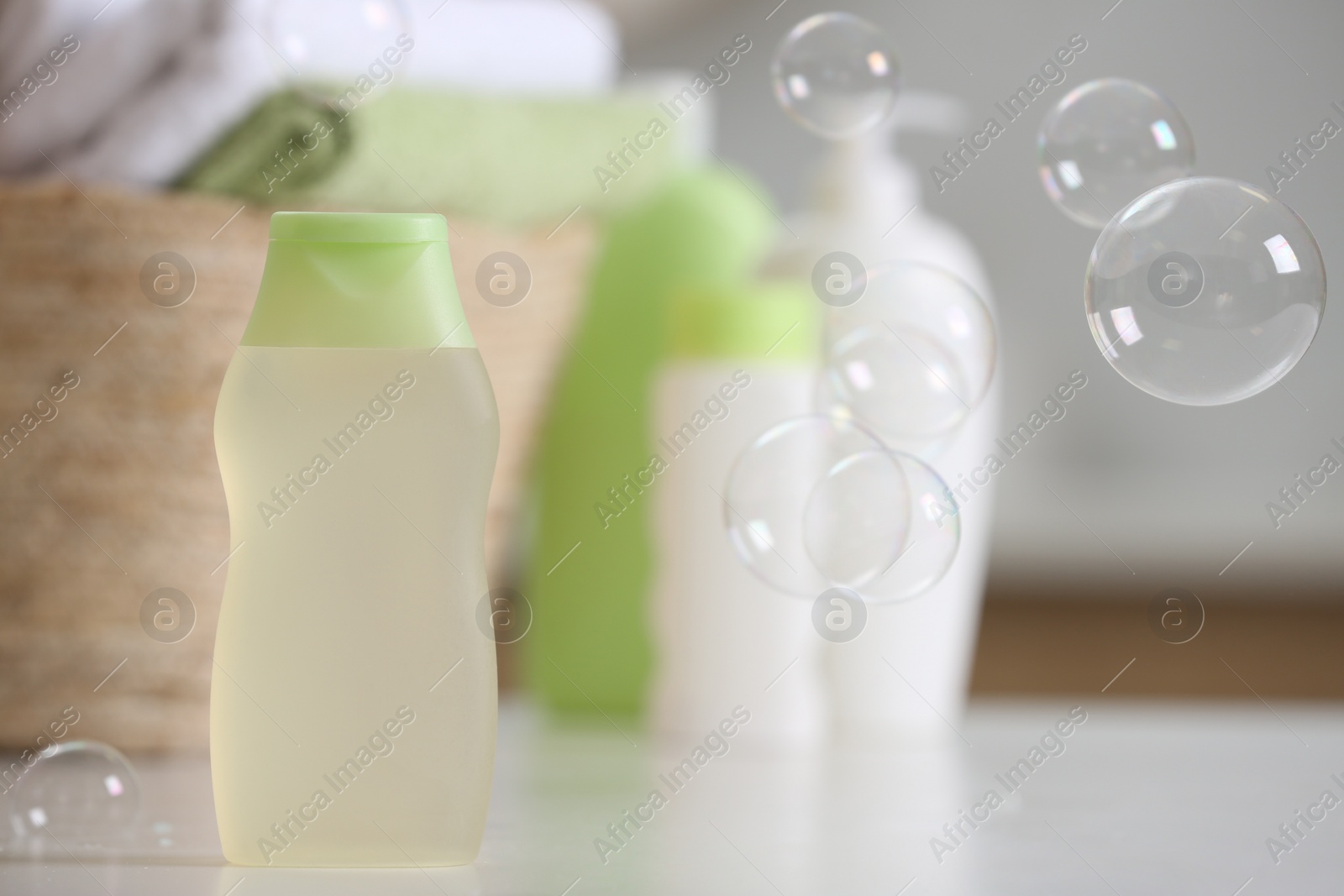 Photo of Bottle of baby cosmetic product on white table, space for text