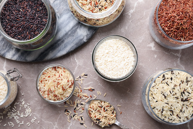 Photo of Flat lay composition with brown and polished rice on grey marble table