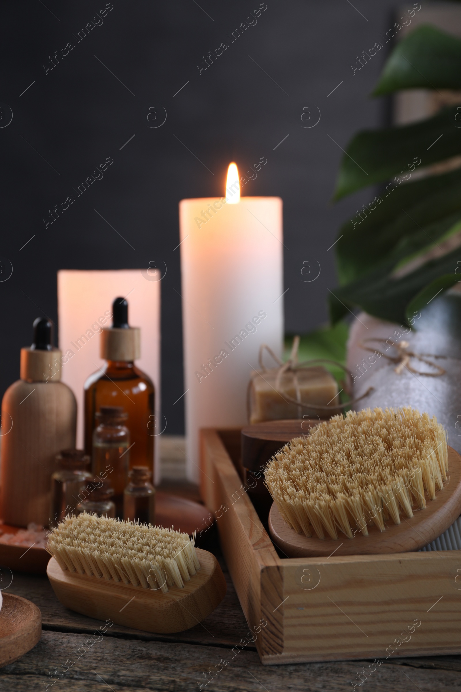 Photo of Composition with different spa products and burning candles on wooden table