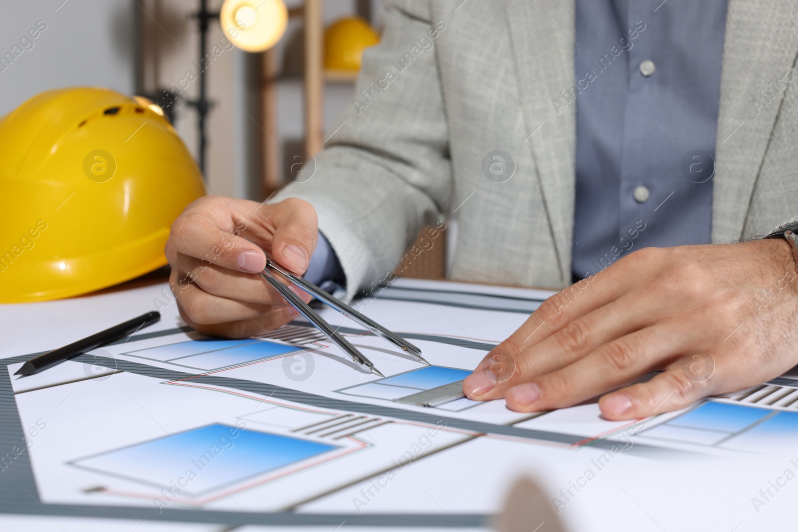 Photo of Architect working with construction drawings in office, closeup