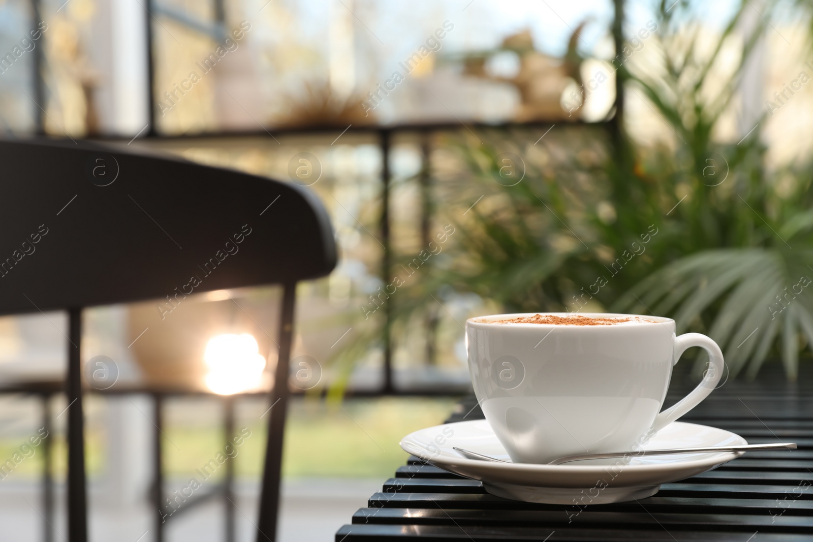 Photo of Ceramic cup of aromatic coffee with foam on wooden table in cafe. Space for text