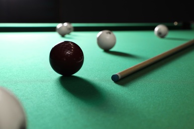 Photo of Balls and cue on modern billiard table