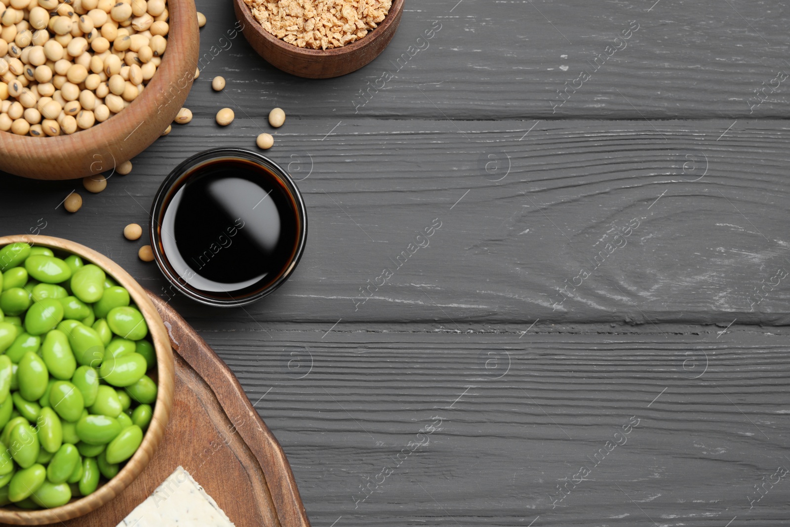 Photo of Different organic soy products on grey wooden table, flat lay. Space for text