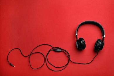 Photo of Stylish modern headphones with earmuffs on color background, top view. Space for text