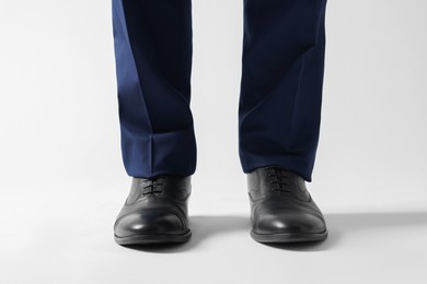 Photo of Businessman in leather shoes on white background, closeup