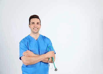 Portrait of medical assistant with stethoscope on light background. Space for text