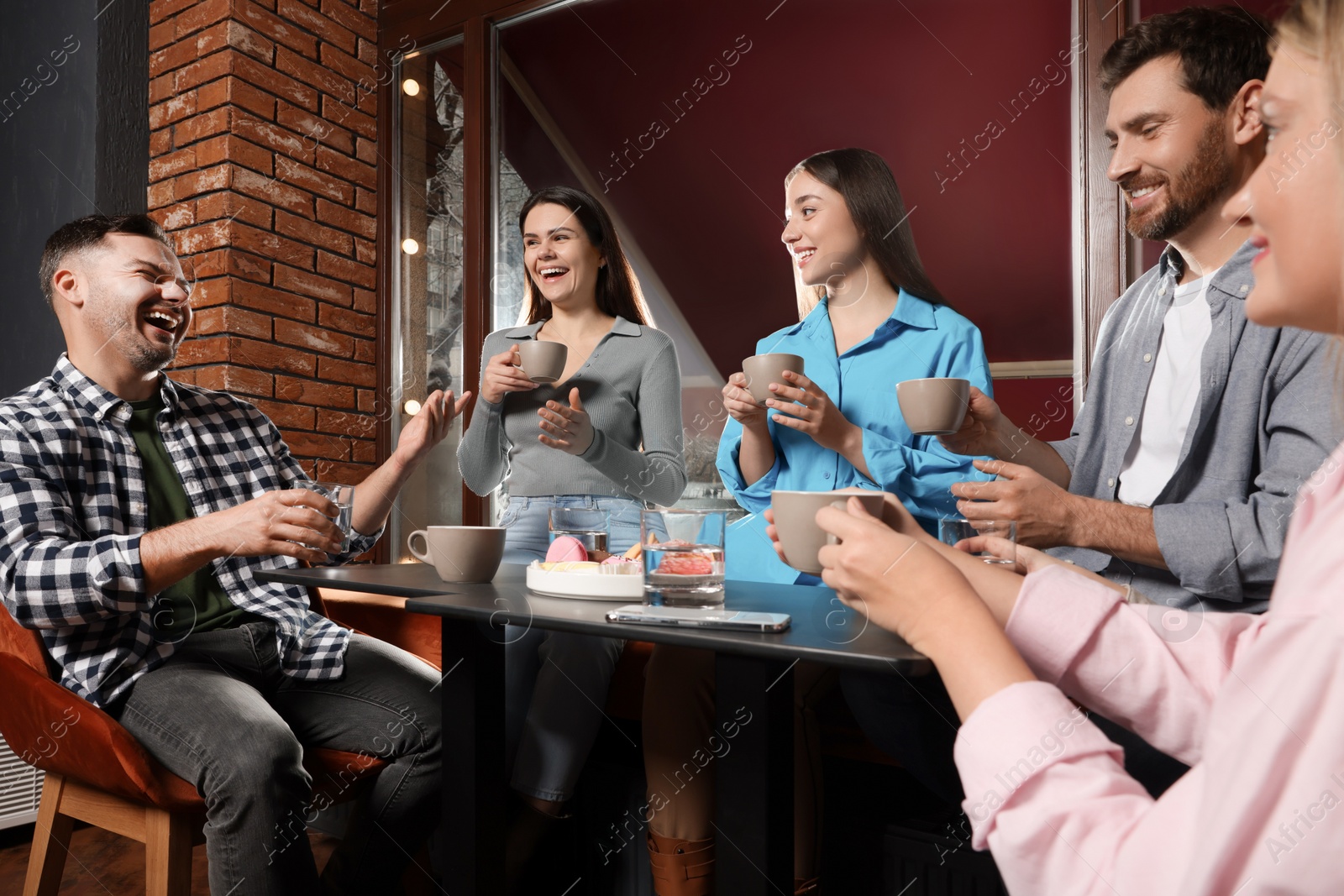 Photo of Friends with coffee spending time together in cafe