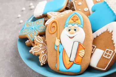Photo of Tasty gingerbread cookies on light grey table, closeup. St. Nicholas Day celebration