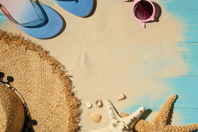 Photo of Flat lay composition with beach objects, sand and space for text on wooden background