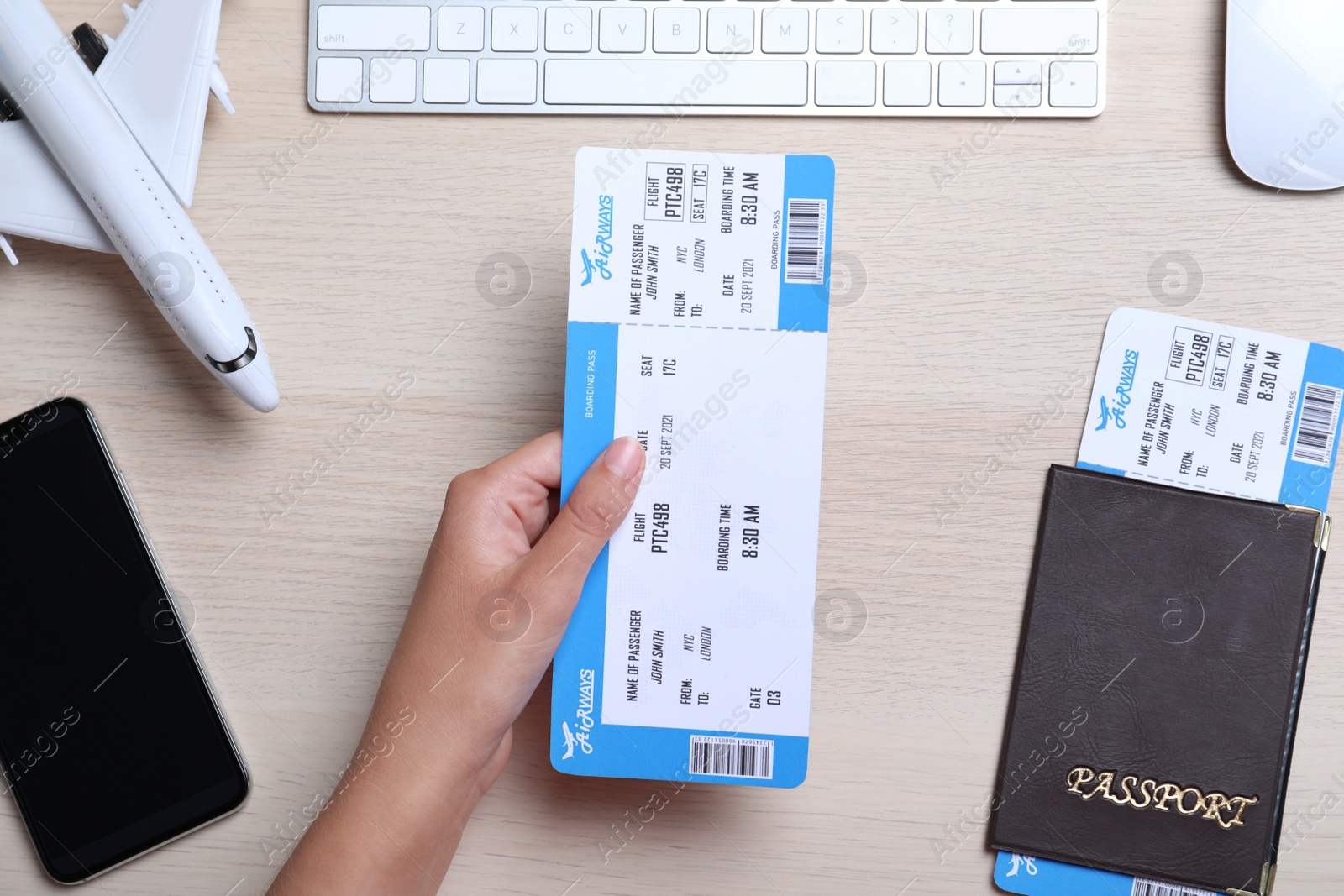 Photo of Woman holding ticket at table, top view. Travel agency concept