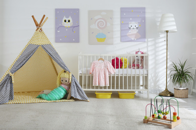 Photo of Baby room interior with cute posters, play tent and comfortable crib