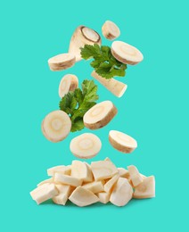 Image of Pieces of parsnip root and leaves falling into pile on turquoise background