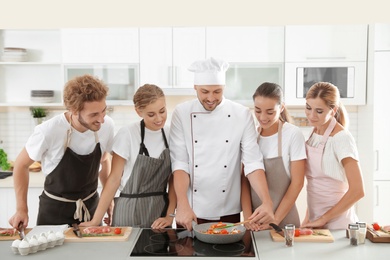 Group of people and male chef at cooking classes