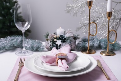 Photo of Stylish table setting with pink fabric napkin and festive decor on white background