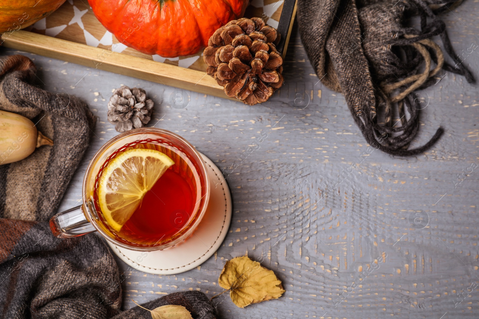 Photo of Flat lay composition with cup of hot drink on grey wooden table, space for text. Cozy autumn atmosphere