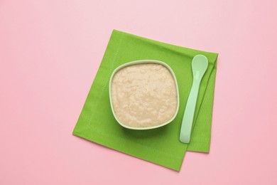 Photo of Healthy baby food in bowl on pink background, top view