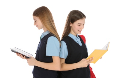 Portrait of teenage girls in school uniform with books on white background