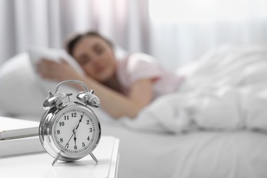 Photo of Woman sleeping at home in morning, focus on alarm clock. Space for text