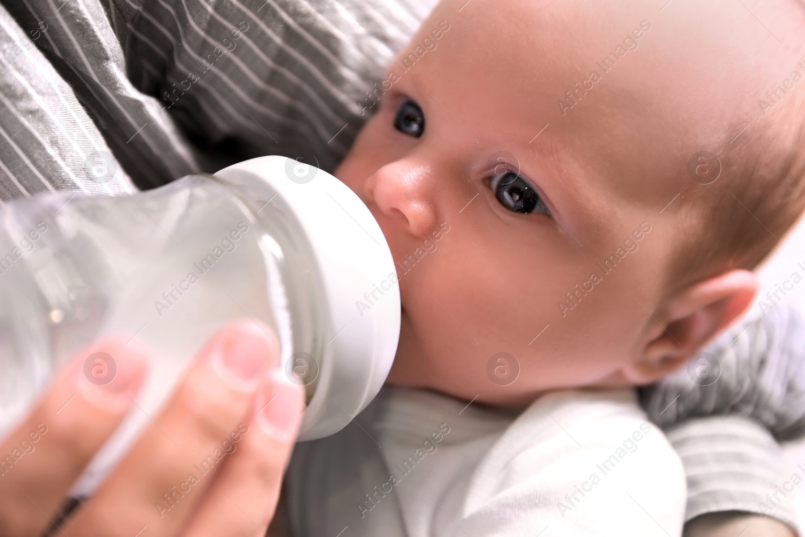 Photo of Mother feeding her little baby from bottle, closeup