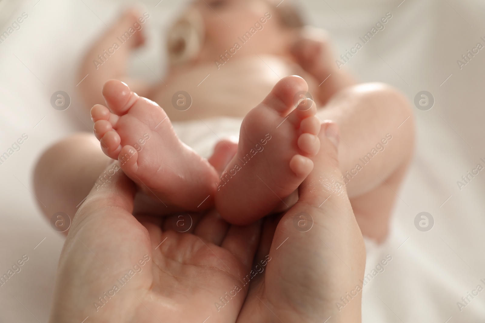 Photo of Mother massaging her cute baby with oil, closeup