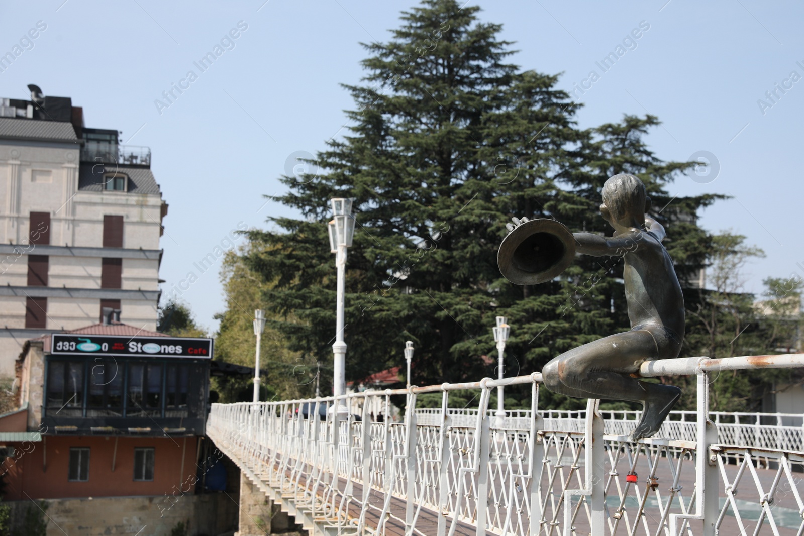 Photo of Kutaisi, Georgia - September 2, 2022: Sculpture of boy with hats on white bridge