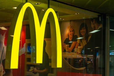 WARSAW, POLAND - AUGUST 05, 2022: Signboard with McDonald's logo on glass wall in restaurant