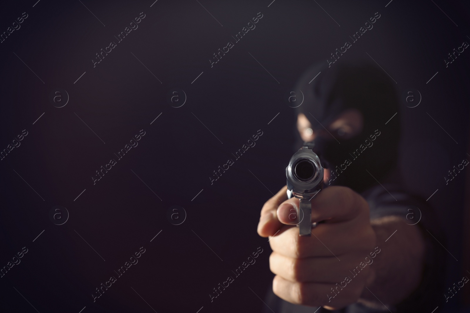 Photo of Professional killer on black background, focus on gun. Space for text