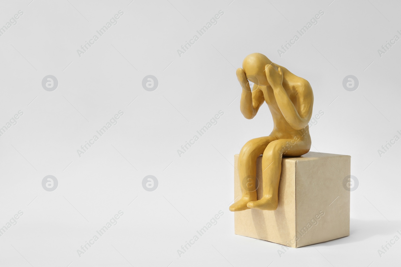 Photo of Plasticine figure of troubled human on white background. Space for text