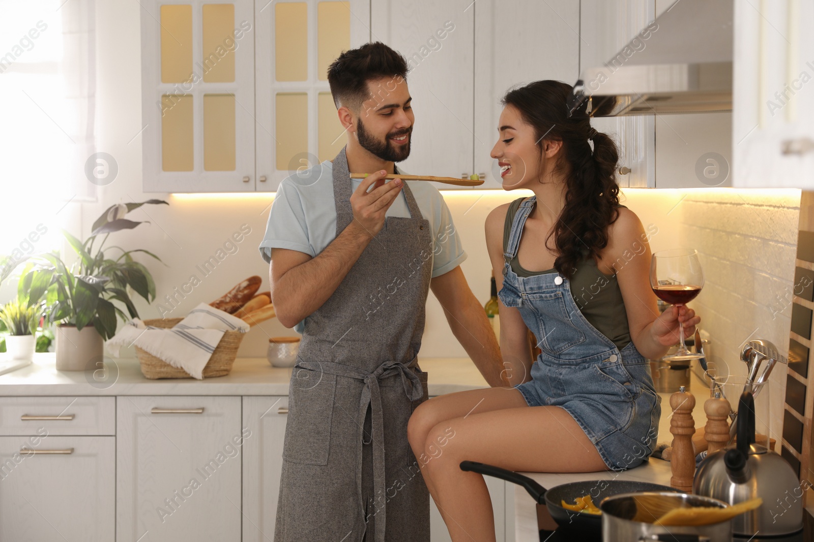 Photo of Lovely young couple cooking together in kitchen