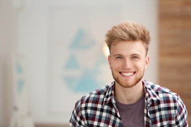 Photo of Portrait of handsome young man in room. Space for text