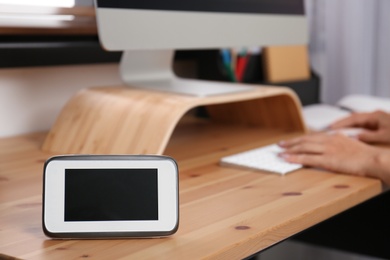 Photo of Baby monitor on table and woman working in home office. Video nanny