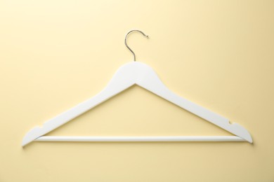 Photo of White hanger on pale yellow background, top view