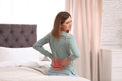 Image of Woman suffering from back pain on bed at home