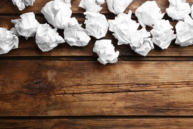 Photo of Crumpled sheets of paper on wooden background, flat lay. Space for text