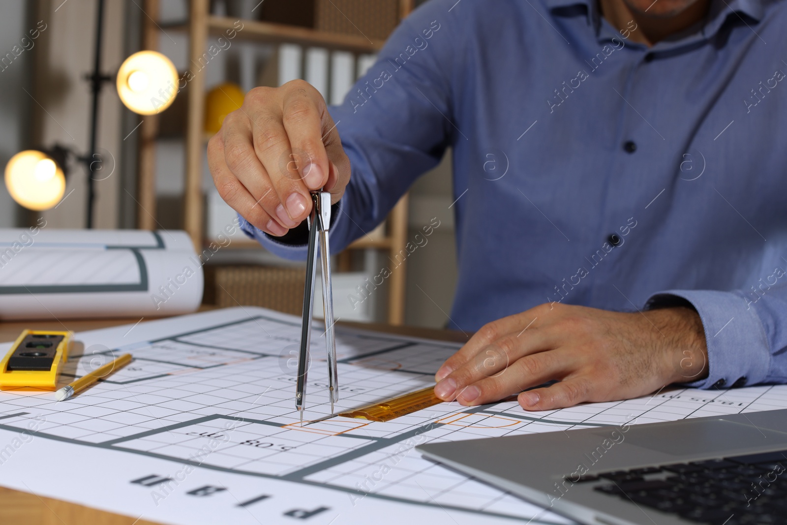 Photo of Architect working with construction drawings in office, closeup