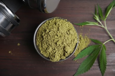 Hemp protein powder, fresh leaves and dumbbells on wooden table, flat lay