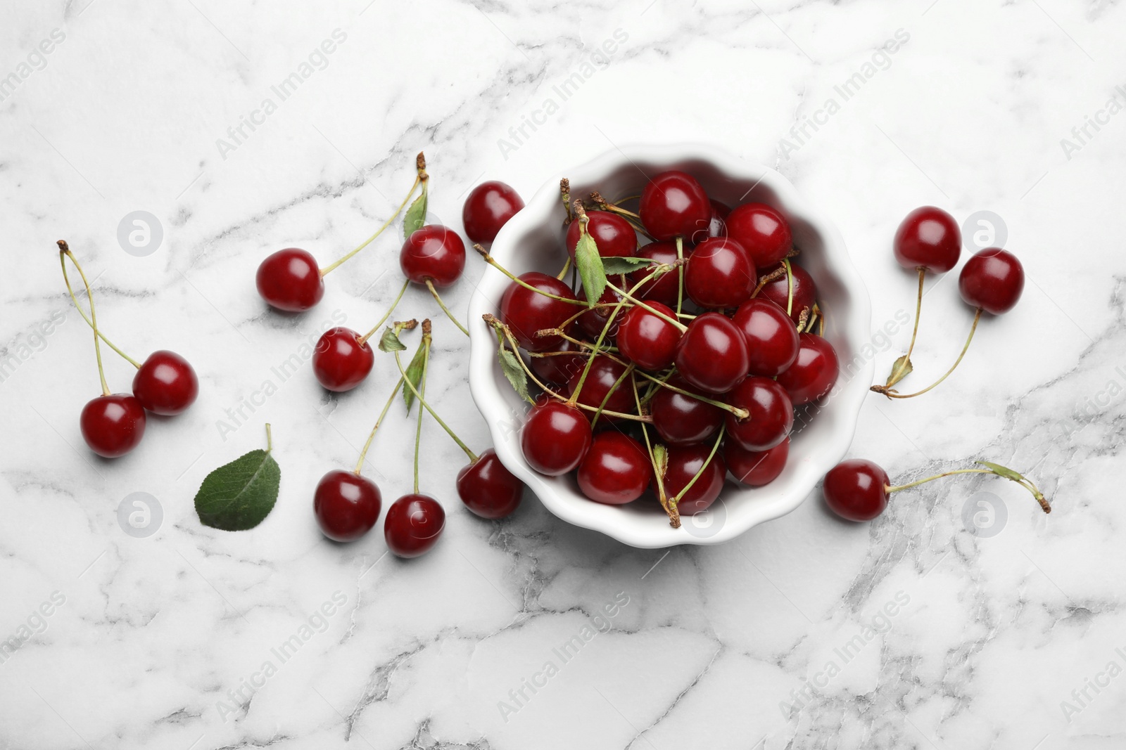 Photo of Bowl of delicious cherries on marble background, flat lay