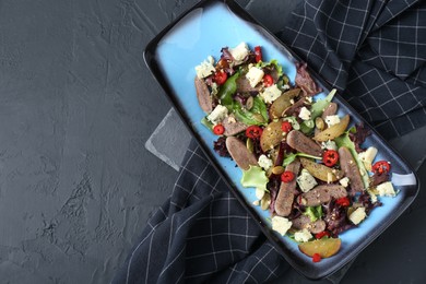 Photo of Delicious salad with beef tongue and cheese on black textured table, top view. Space for text